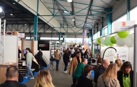Allées du stand de la Foire de Cavaillon avec visiteurs et exposants.